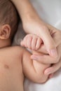 Mother`s hand holding infant baby boy`s hand with care. Royalty Free Stock Photo