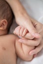 Mother`s hand holding infant baby boy`s hand with care. Royalty Free Stock Photo