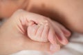 Mother`s hand holding infant baby boy`s hand with care. Royalty Free Stock Photo