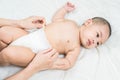 Mother`s hand taking care of little boy. Mom giving baby a diaper change on bed Royalty Free Stock Photo