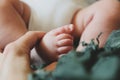 Female hand touching cute tiny baby foot. Maternity concept, mother`s day. Royalty Free Stock Photo