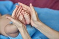 Mother`s hands carefully holding baby`s feet, selective focus Royalty Free Stock Photo