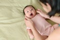 MotherÃ¢â¬â¢s hands holding head of cute cheerful Asian little newborn baby girl Royalty Free Stock Photo