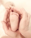 Mother's hands keep baby's foot with care