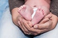 Mother`s hands tenderly holding her baby`s feet Royalty Free Stock Photo