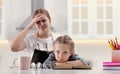 Mother scolding her daughter while helping with homework