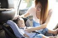 Mother securing baby in the car seat