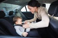 Mother securing her baby in the car seat