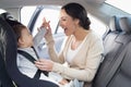 Mother securing her baby in the car seat