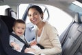 Mother securing her baby in the car seat Royalty Free Stock Photo