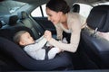 Mother securing her baby in the car seat