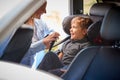 Mother Securing Son Into Rear Child Seat Before Car Journey Royalty Free Stock Photo