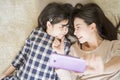 Mother is selfie with her little daughter using a smart phone camera while eye contact with daughter .Asian family concept. Royalty Free Stock Photo