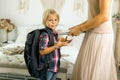 Mother, sending her firstgrader boy to school, first day at school, giving him books and a box with snack