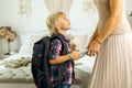 Mother, sending her firstgrader boy to school, first day at school, giving him books and a box with snack