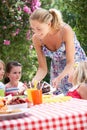 Mother Serving Birthday Cake To Group Of Children