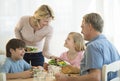 Mother Serving Food To Family At Table Royalty Free Stock Photo