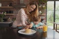 Mother serving food to her son at dining table Royalty Free Stock Photo