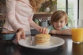 Mother serving food to her son at dining table Royalty Free Stock Photo