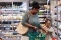 Mother shopping in supermarket with little daughter and buying vegetables Royalty Free Stock Photo