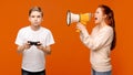 Mother shouting through megaphone at boy with joystick Royalty Free Stock Photo