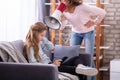 Mother Shouting Through Megaphone At Girl Using Digital Tablet Royalty Free Stock Photo