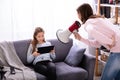 Mother Shouting Through Megaphone At Girl Using Digital Tablet Royalty Free Stock Photo