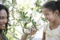 Mother Showing Flower Plant To Daughter