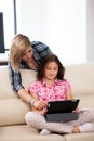 Mother showing her cute teenage daughter something on the tablet PC Royalty Free Stock Photo
