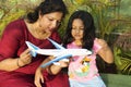Mother showing her daughter a toy airplane while little girl observing it carefully, Pune Royalty Free Stock Photo