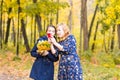 Mother showing her Teenage girl photos on mobile phone outdoor in autumn nature Royalty Free Stock Photo