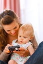 Mother showing interested baby photos in camera