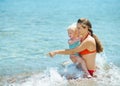 Mother showing something to baby girl at seaside Royalty Free Stock Photo