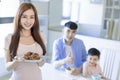 Mother showing tasty food and father showing thumbs up. Happy Asian  family having dinner at home Royalty Free Stock Photo