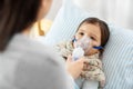 Mother and sick daughter with oxygen mask in bed