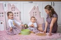 Mother and sisters sit on the floor in the kitchen and play with dry pasta Royalty Free Stock Photo