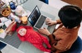 Mother sits and works at a laptop next to the lying baby on the table