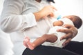 mother Sitting on bed, and feed milk from bottle milk to her 12-day-old African baby Royalty Free Stock Photo