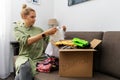 Mother sitting on couch and sorting child clothes for donation