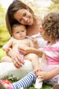 Mother Sitting With Daughters In Field