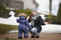 Mother sitting in front of her child who is walking to her