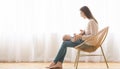 Mother sitting in wicker chair holding newborn baby on lap Royalty Free Stock Photo