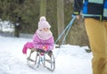 Mother sledding his little girl on an old sled