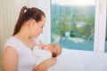 Mother with a sleeping baby in her arms at the window. Royalty Free Stock Photo