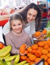 Mother and small cheerful daughter buying citrus fruits Royalty Free Stock Photo