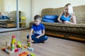 Mother and small child, boy at home sitting on couch, using laptop, relax. Working on mobile phone from home. Happy family Royalty Free Stock Photo