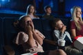 Mother with small children in the cinema, watching film.