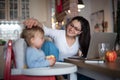 Mother with small daughter in kitchen, home office with children concept.