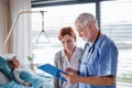 Mother of small hospitalized girl talking to doctor in hospital. Royalty Free Stock Photo