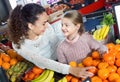 Mother and small pretty daughter buying citrus fruits Royalty Free Stock Photo